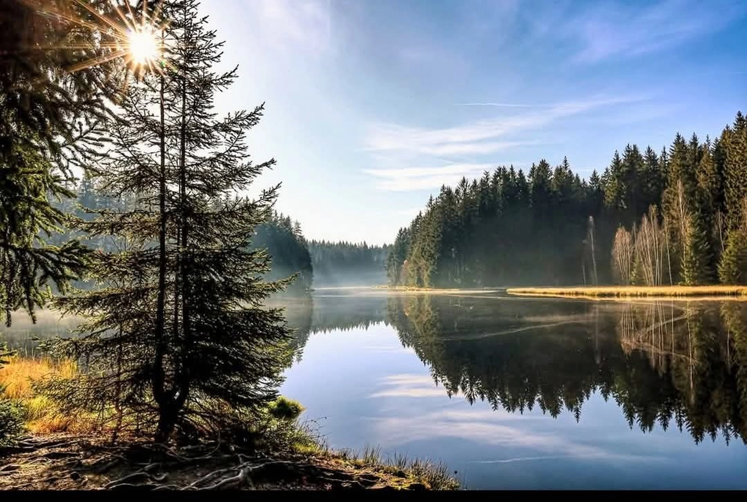 Reiselust Hahnenklee - Ferienhaus - ein ruhiger Moment beim Stand-Up-Paddleboarding (SUP) auf einem See.